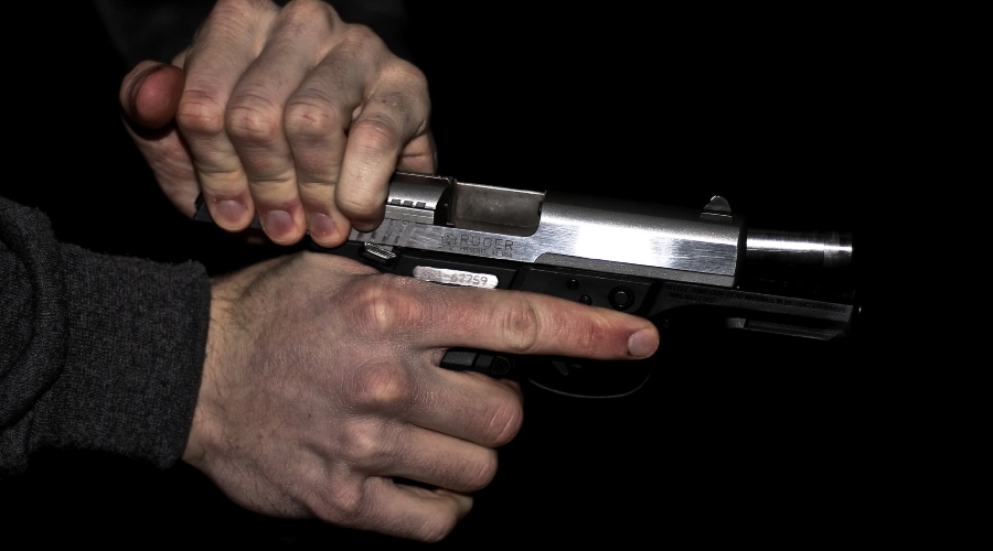 Mužské ruce drží zbraň