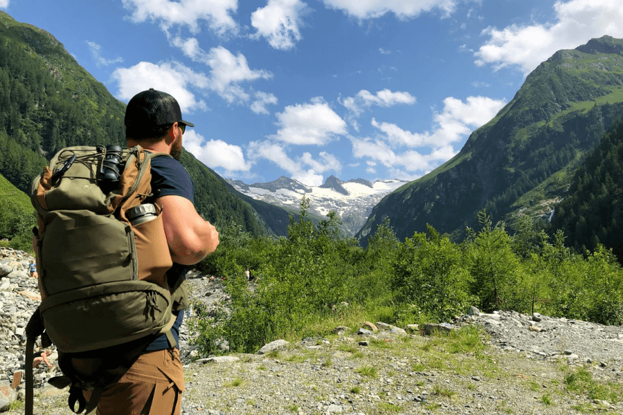 Muž s batohem a termoskou na horách