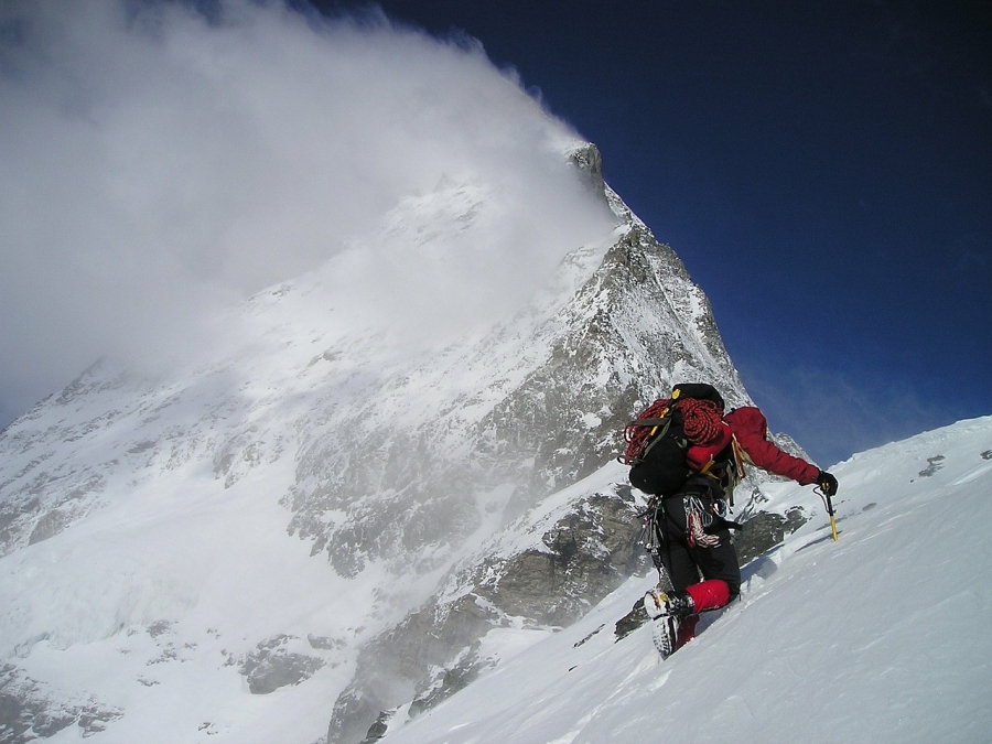Muž lezoucí na zasněženou horu