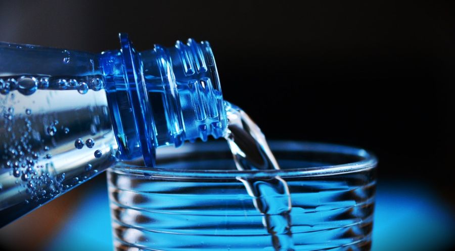 Voda z pet lahve nalévaná do skleničky 