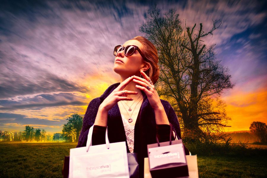 Žena s nákupními taškami v přírodě se slunečními brýlemi